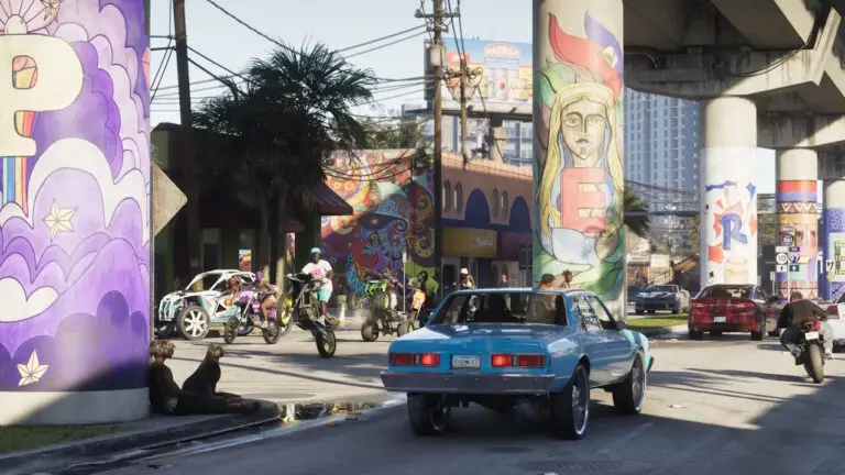 Cena de GTA 6 mostra carro sedã azul em rua de Vice City, com motociclistas, murais coloridos e viaduto ao fundo.