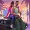 Arte conceitual de GTA 6 com Jason e Lucia sentados sobre carro vintage em Vice City ao pôr do sol, cercados por palmeiras.